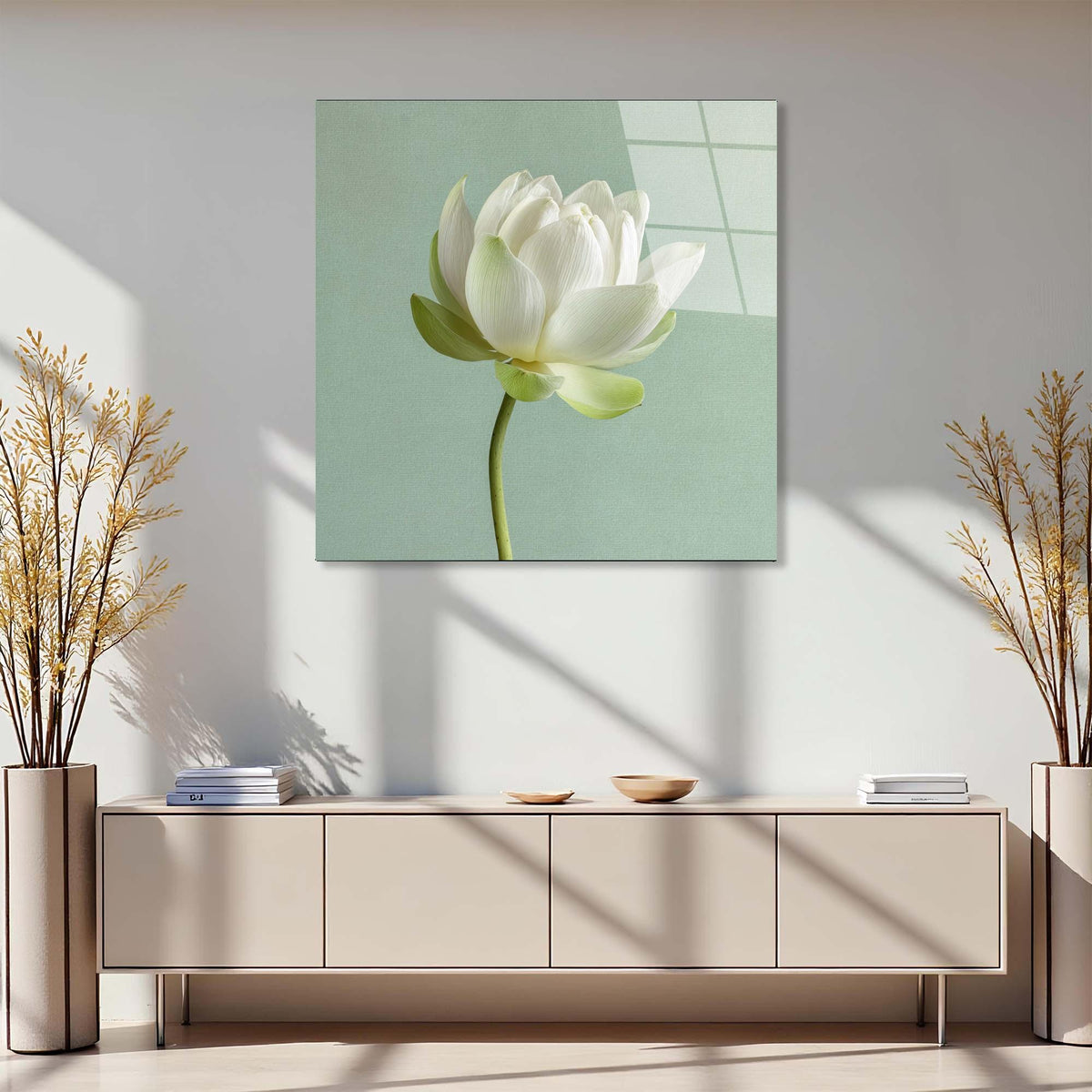 Modern interior with a light-colored cabinet, decorative plants, and a framed picture of a white flower on the wall.