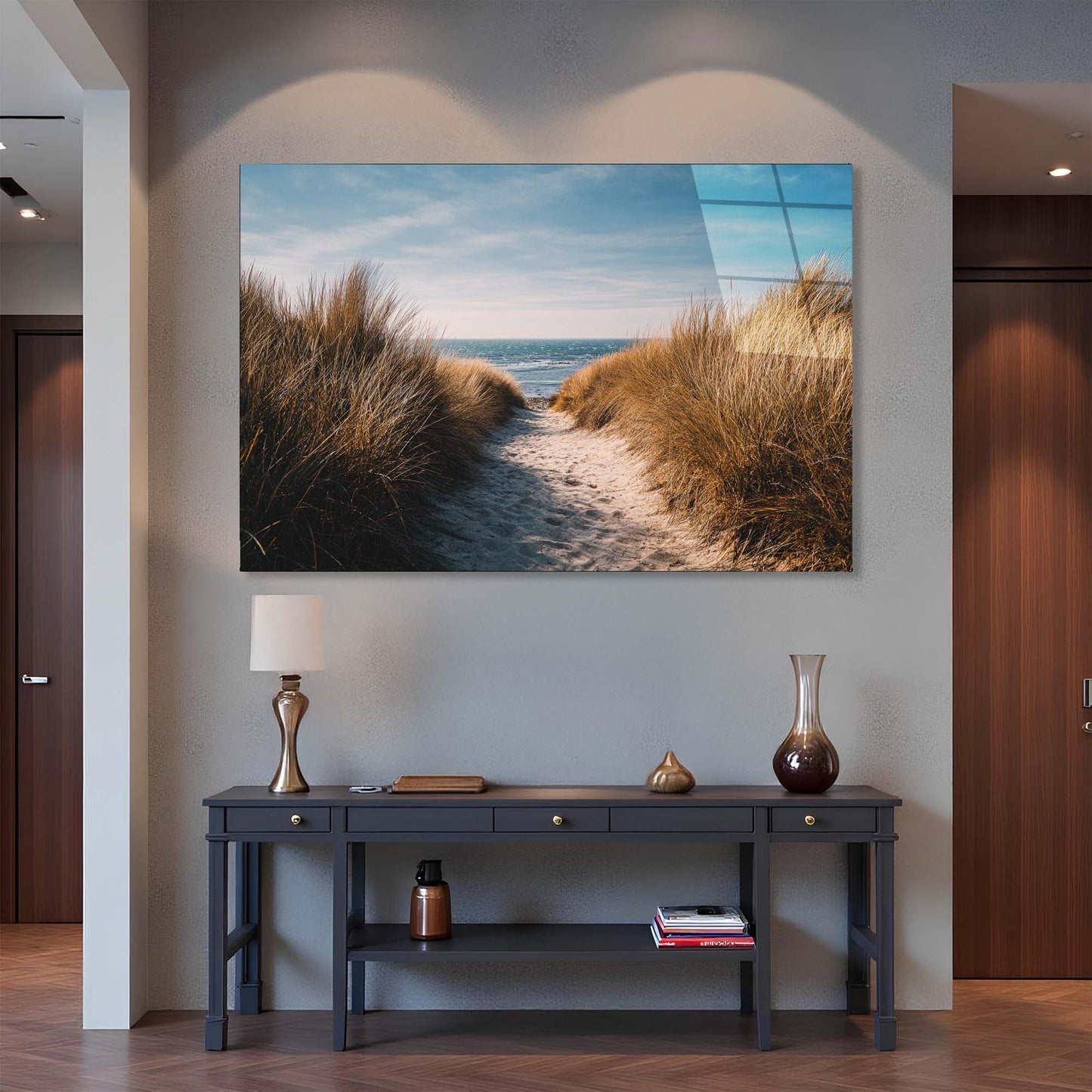 Framed artwork of a beach scene above a console table in a room.