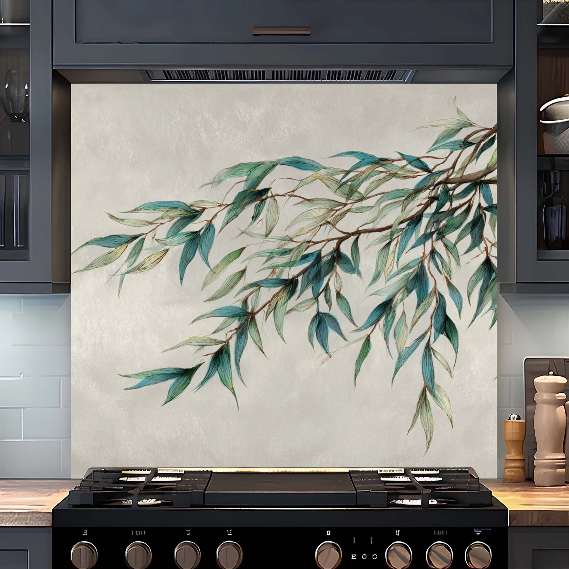 Decorative kitchen backsplash with green leaf design above a stove.