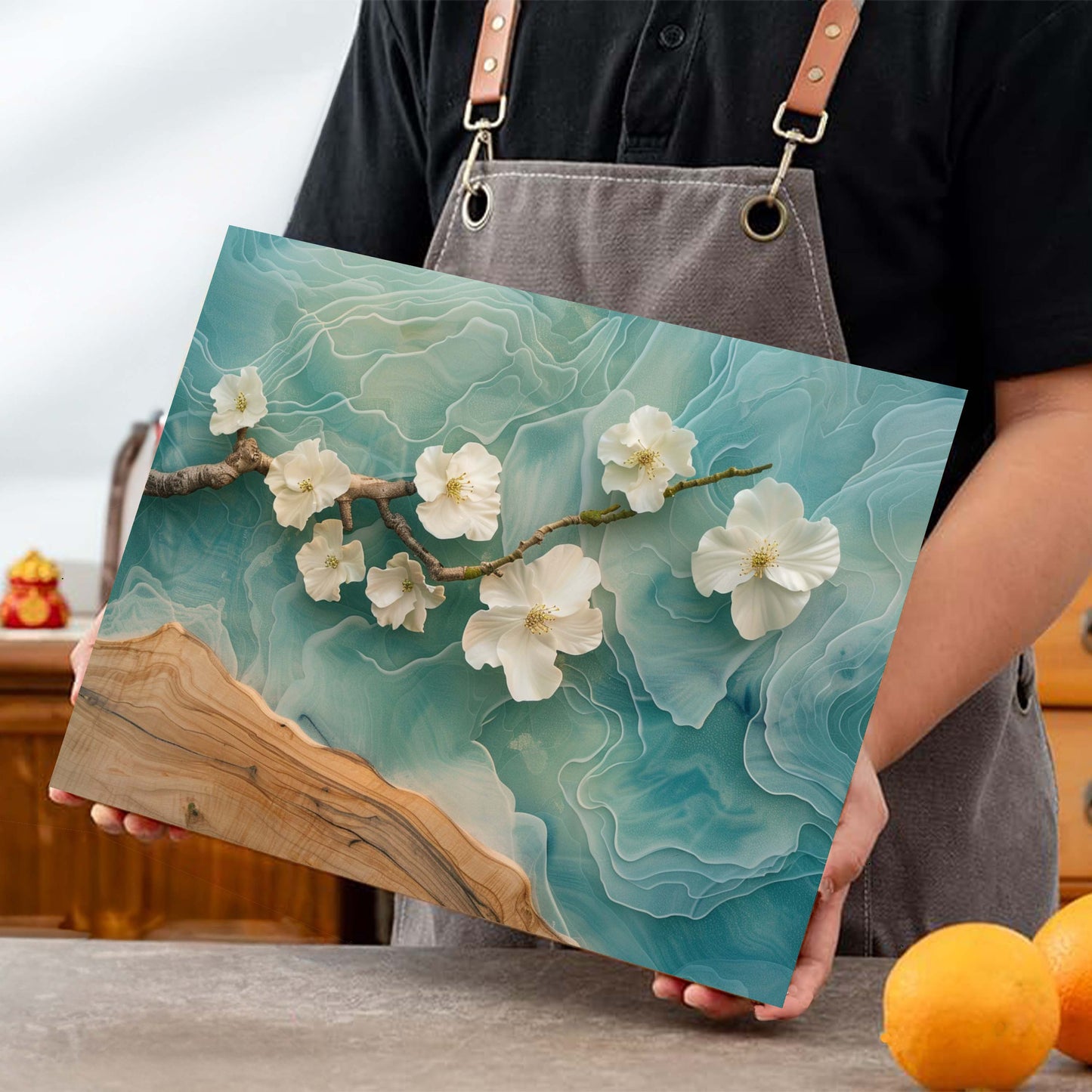 Person holding a wooden cutting board with floral design