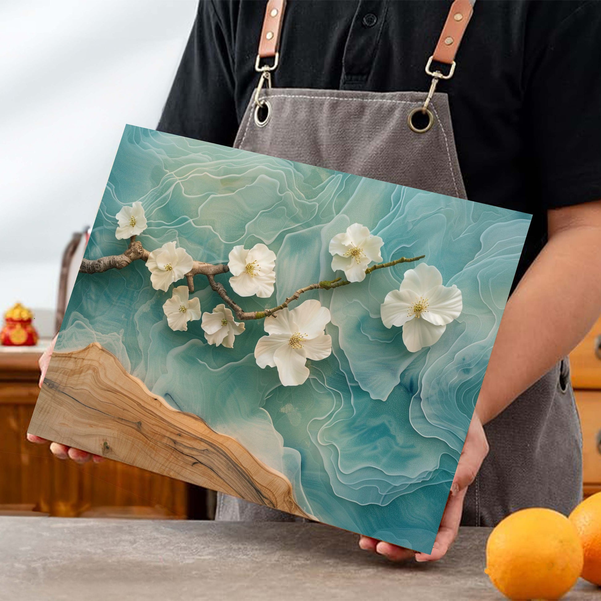 Person holding a wooden cutting board with floral design