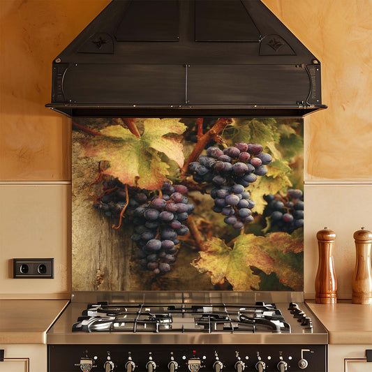 Stainless steel gas stove with decorative glass backsplash featuring grapes and leaves in a kitchen setting.