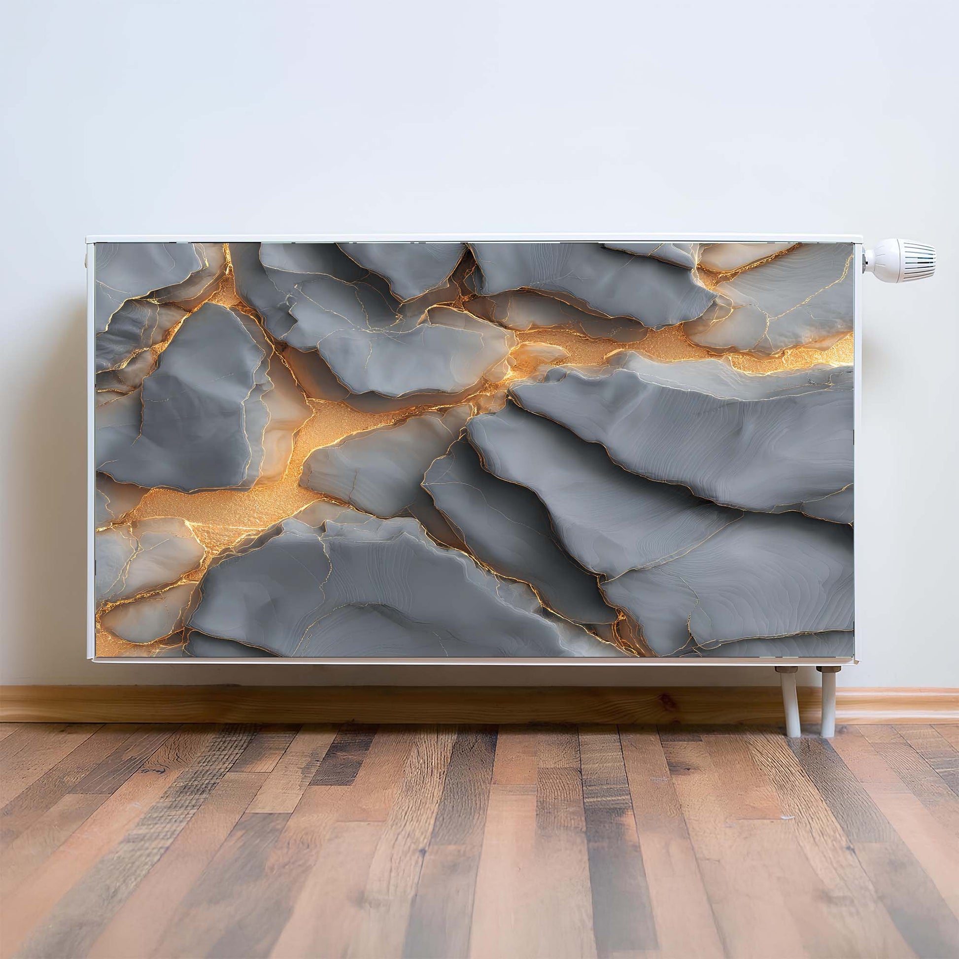 Abstract magnetic radiator cover with gold and gray patterns on a white wall.