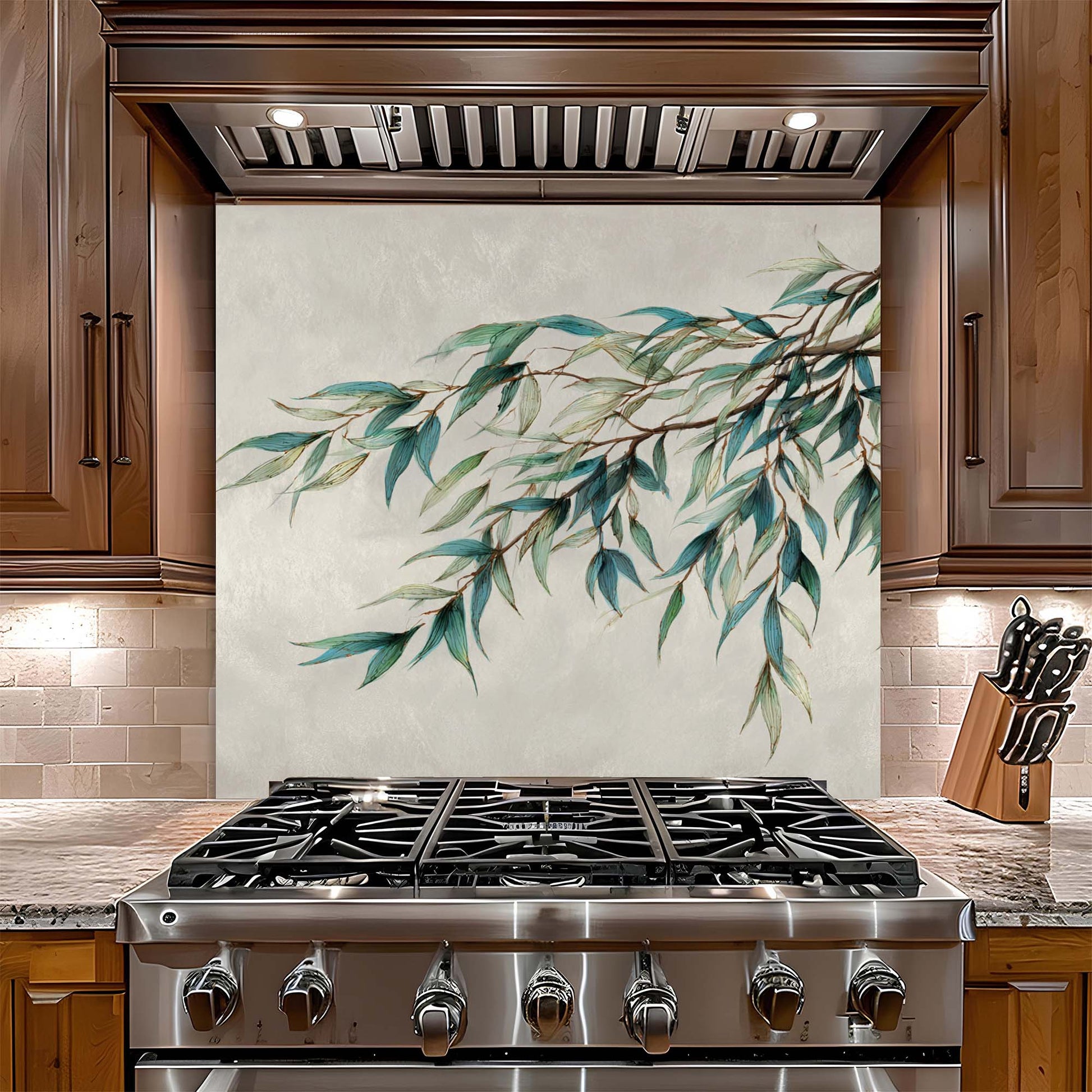 Stainless steel gas stove with decorative leaf pattern glass backsplash on the wall behind it in a kitchen setting.