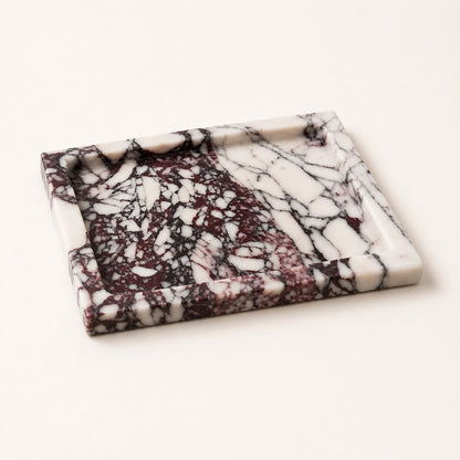 A rectangular marble tray with a raised rim, featuring a marbled pattern of white, deep burgundy, and black veining, photographed on a clean off-white background.