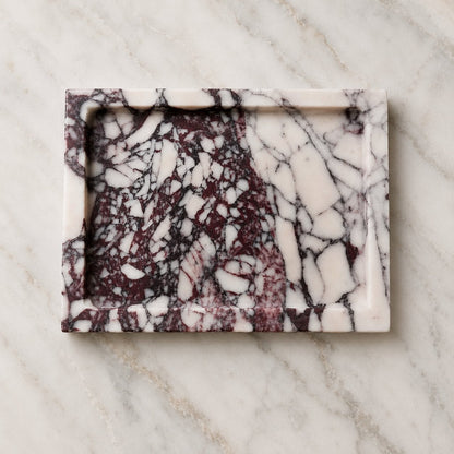 A rectangular marble tray with a raised rim, featuring a white and deep burgundy marble pattern, set on a light gray marble surface.