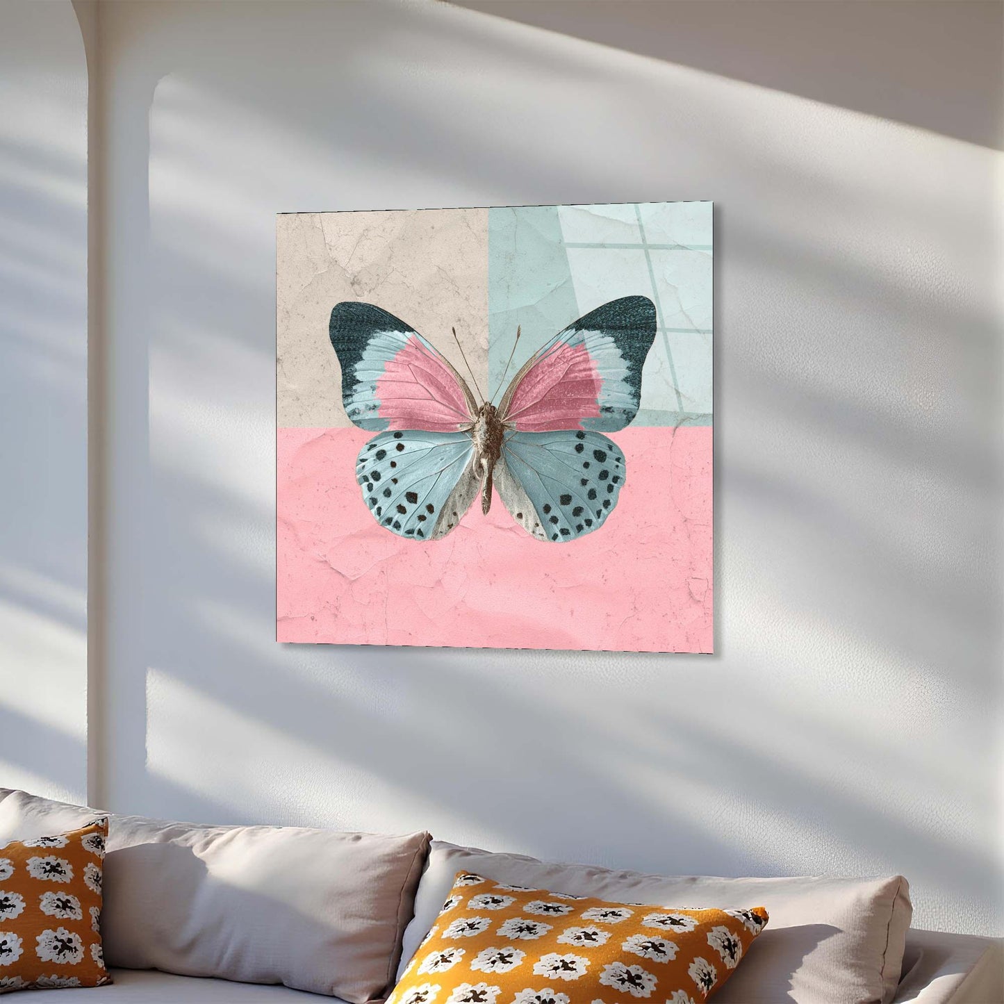 Butterfly artwork on a wall above a sofa with decorative pillows.