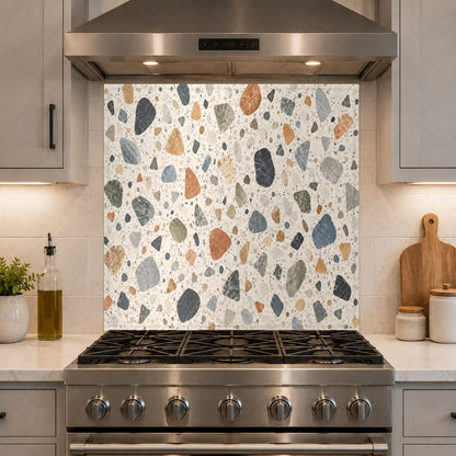 Durable and easy-to-clean terrazzo mosaic glass kitchen backsplash behind a pro-style range.