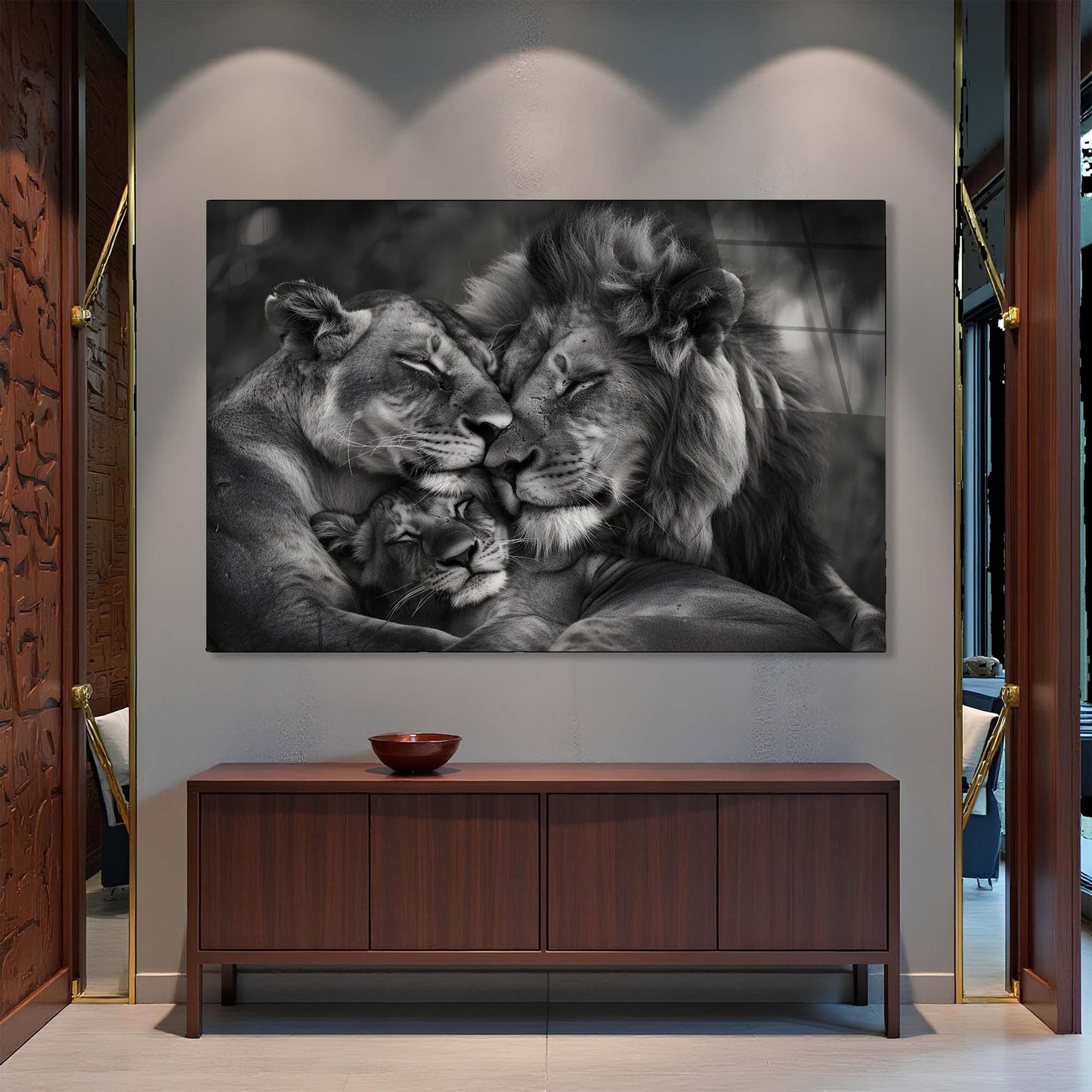Black and white photo of a lion and cub on a wall above a wooden cabinet.