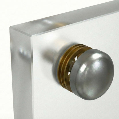 Metallic screw cap on a clear glass backsplash
