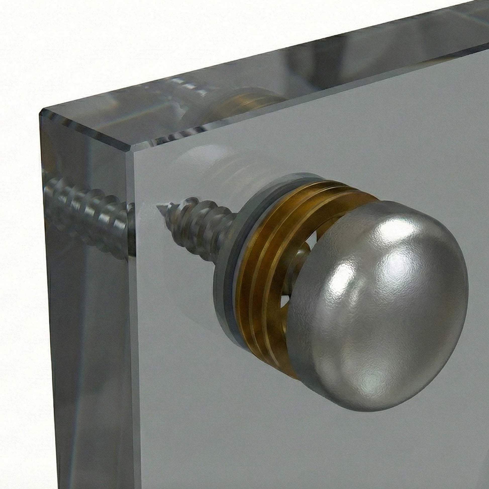 Metallic knob on a clear acrylic block with glass backsplash