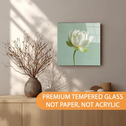 Canvas print of a white flower on a wall above a wooden shelf with decorative items.