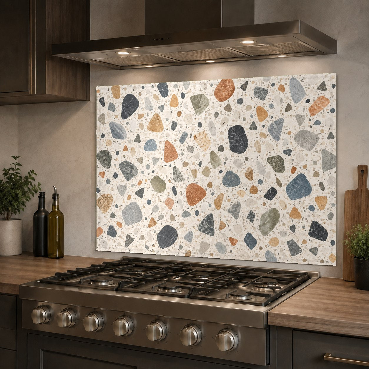 Chic terrazzo stone mosaic glass backsplash protecting the wall behind a stainless steel kitchen sink.