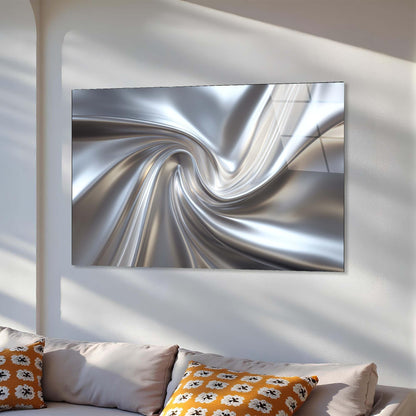 Abstract silver artwork on a white wall above a sofa with patterned cushions.