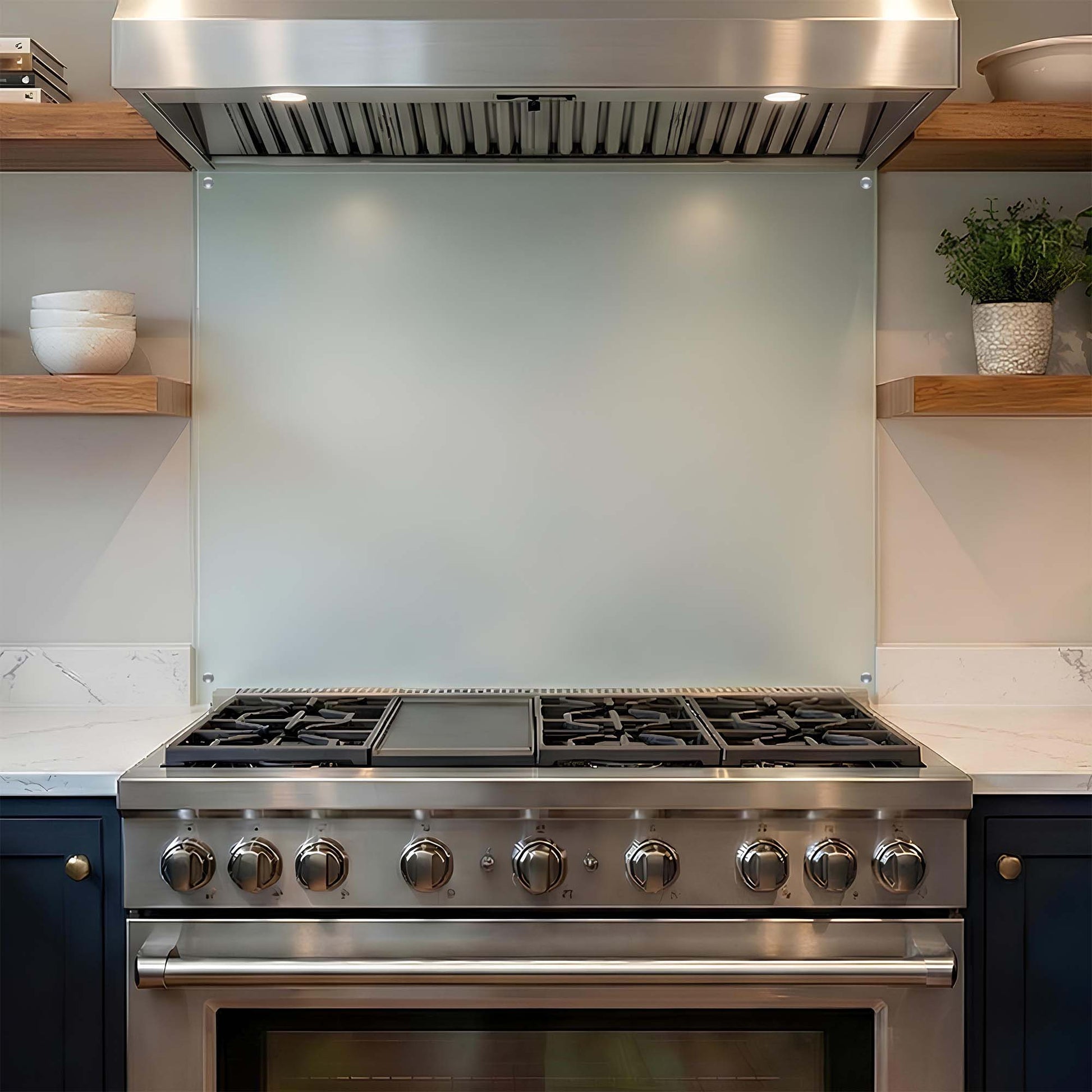 Stainless steel kitchen stove with glass backsplash in a modern kitchen.