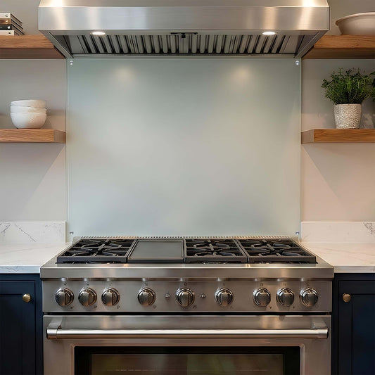 Stainless steel kitchen stove with glass backsplash in a modern kitchen.
