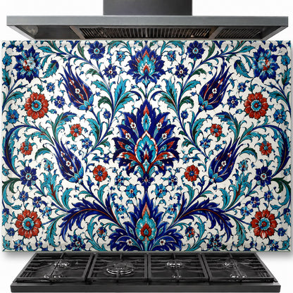 Traditional blue and white Iznik tile pattern on a tempered glass backsplash installed behind a modern gas stove.