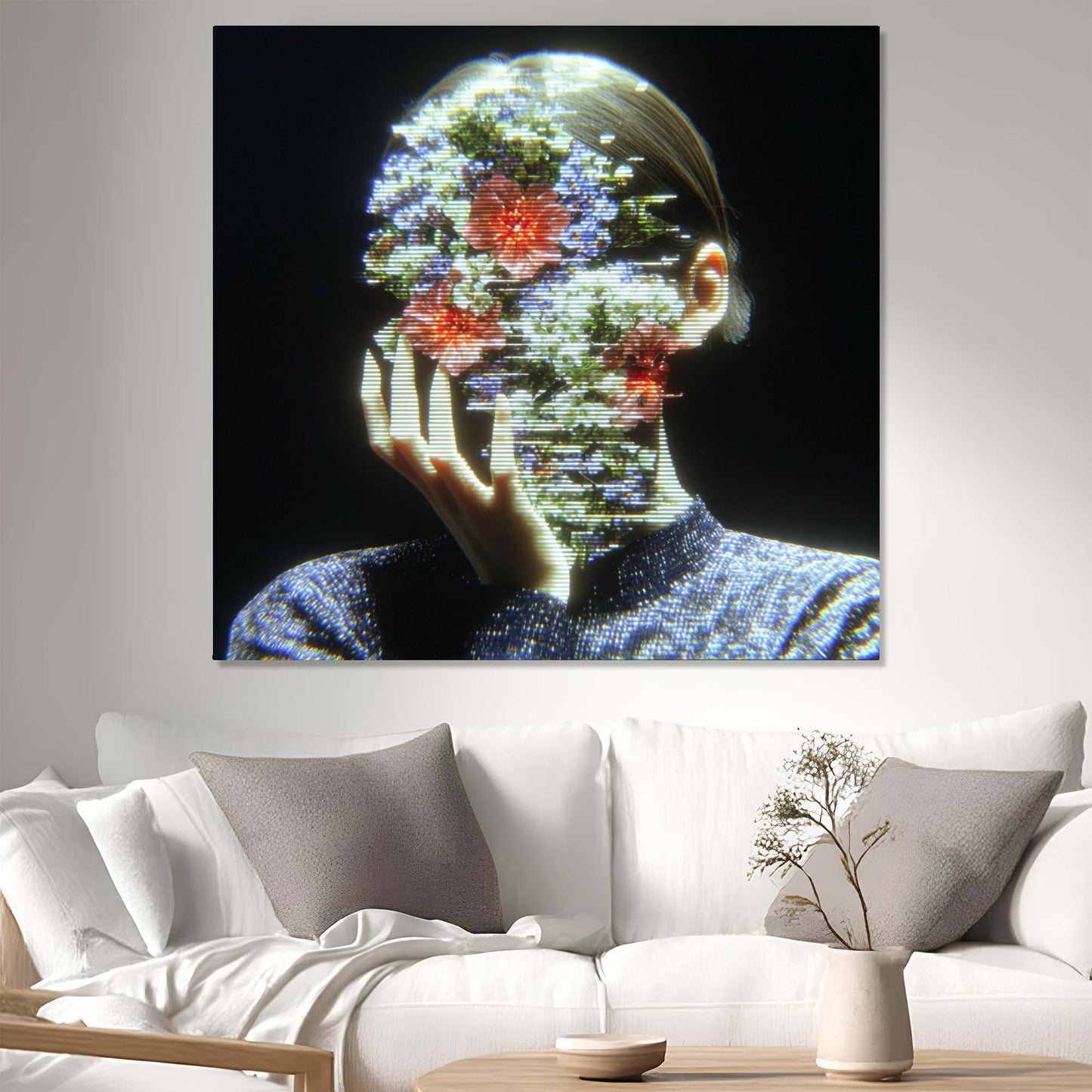 Abstract artwork of a person with floral elements displayed on a wall above a white sofa.