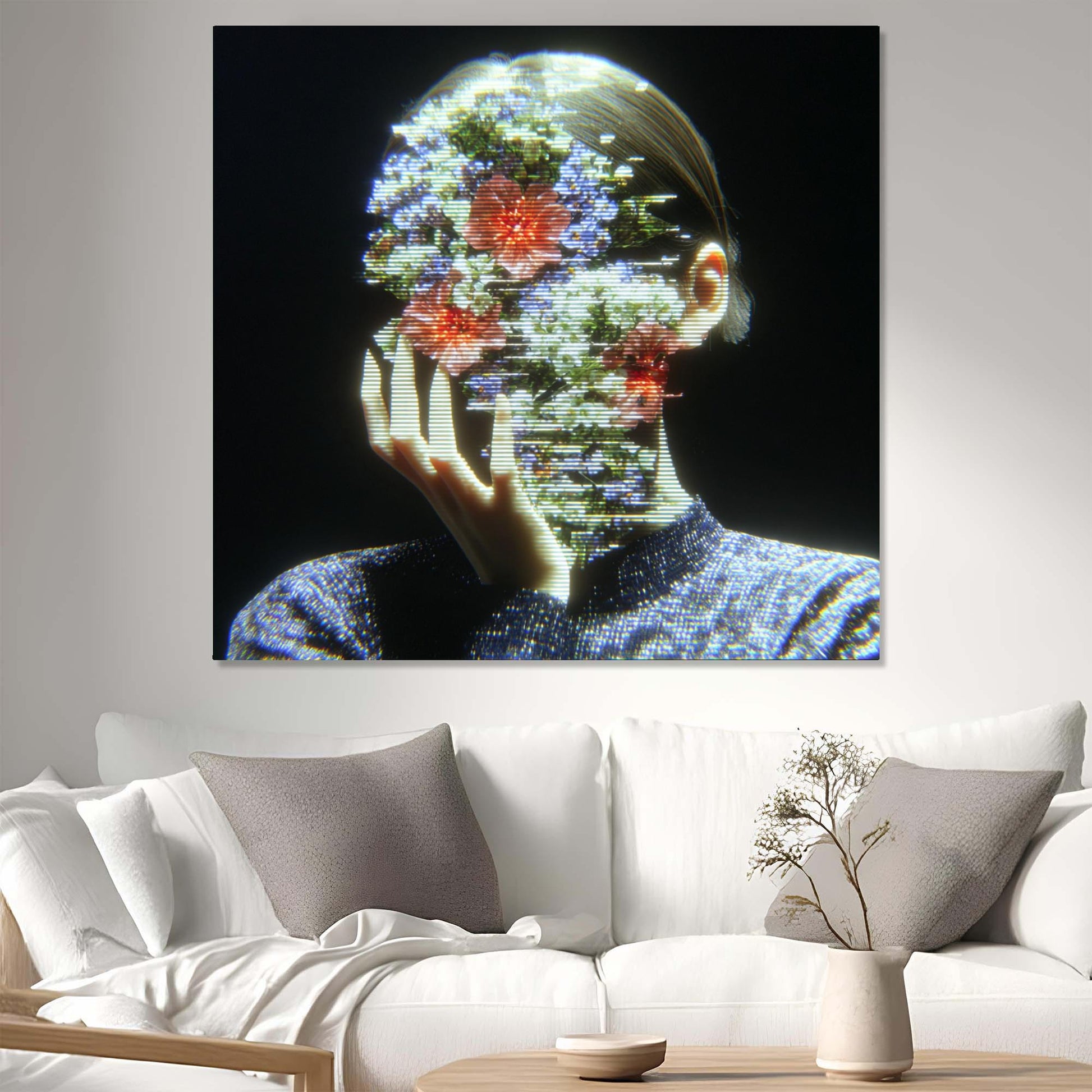 Abstract artwork of a person with floral elements displayed on a wall above a white sofa.