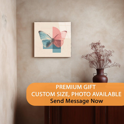 Framed butterfly artwork on a wall with a vase of dried flowers below.