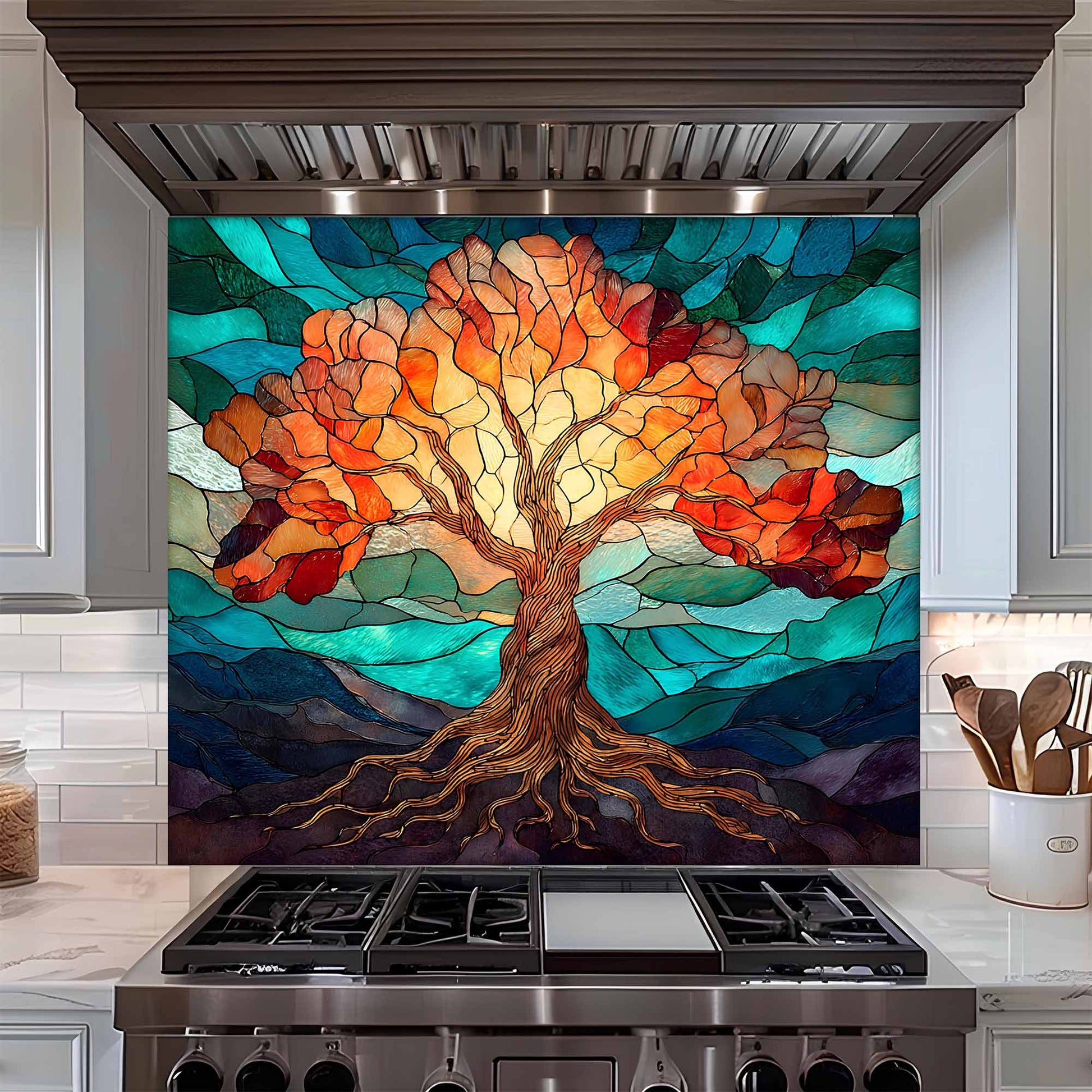 Stainless steel range hood with a colorful stained glass-style tree design  glass backsplash above a stove.