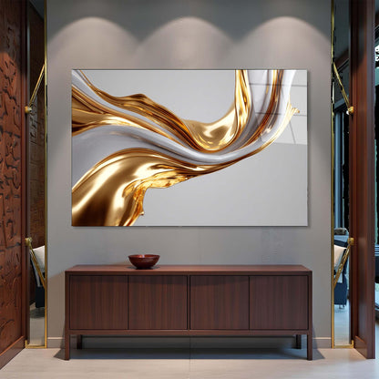Abstract gold and white painting on a wall above a wooden cabinet.