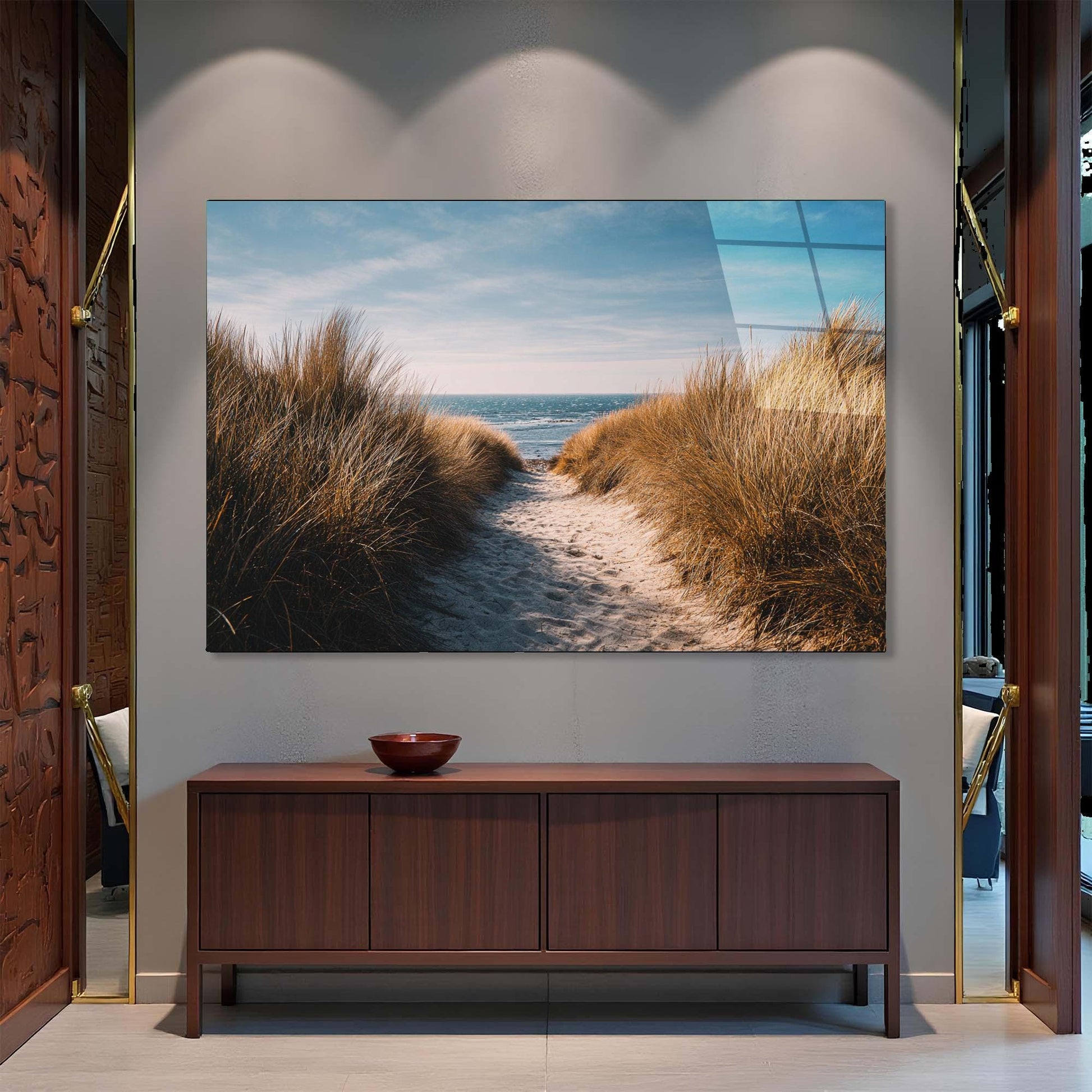 TV mounted on a wall displaying a beach scene, below which is a wooden cabinet.
