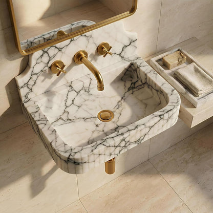 Marble sink with gold fixtures in a bathroom setting
