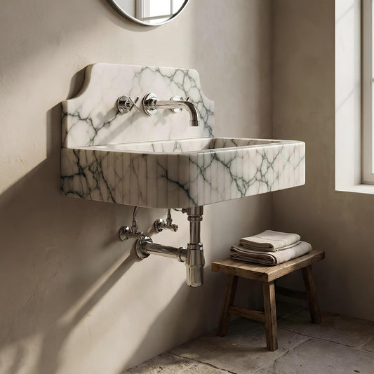 Marble-patterned wall-mounted sink with metallic fixtures in a bathroom setting.