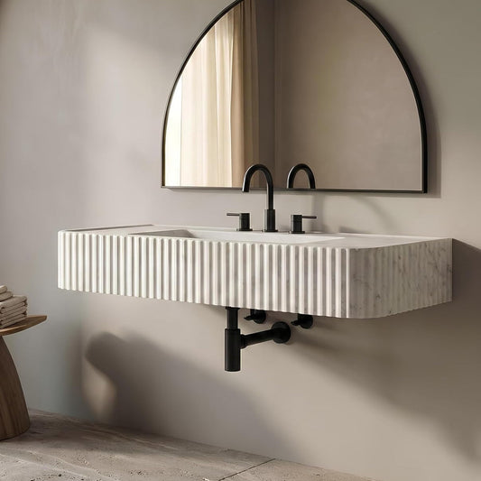 Bathroom with a modern sink and round mirror on a neutral wall.