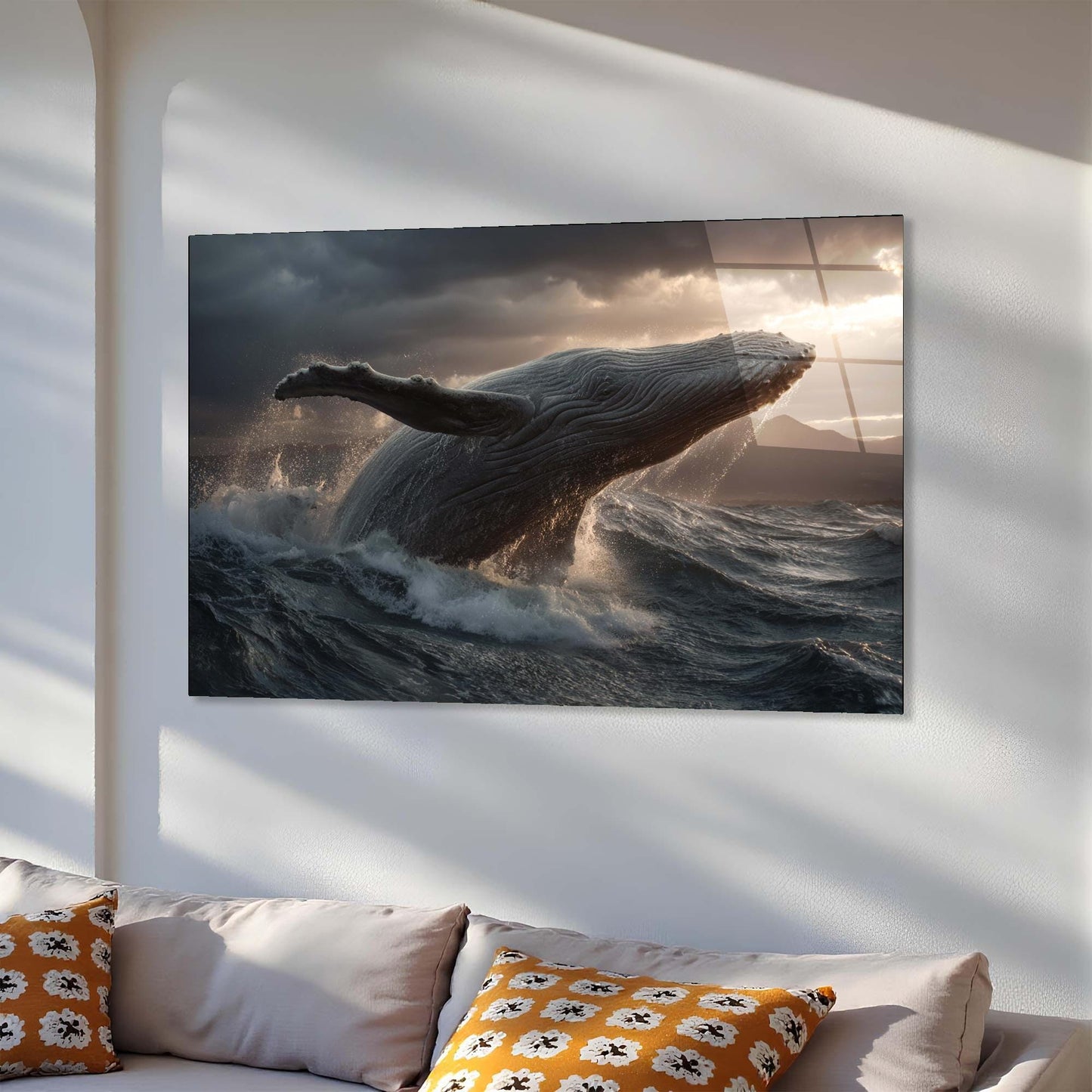 Large TV screen displaying a whale in the ocean with a sunset, mounted on a white wall above a sofa.