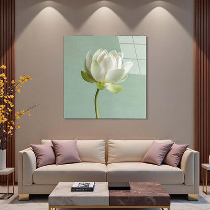 Modern living room with a beige sofa, decorative pillows, and a wall art piece of a white flower.