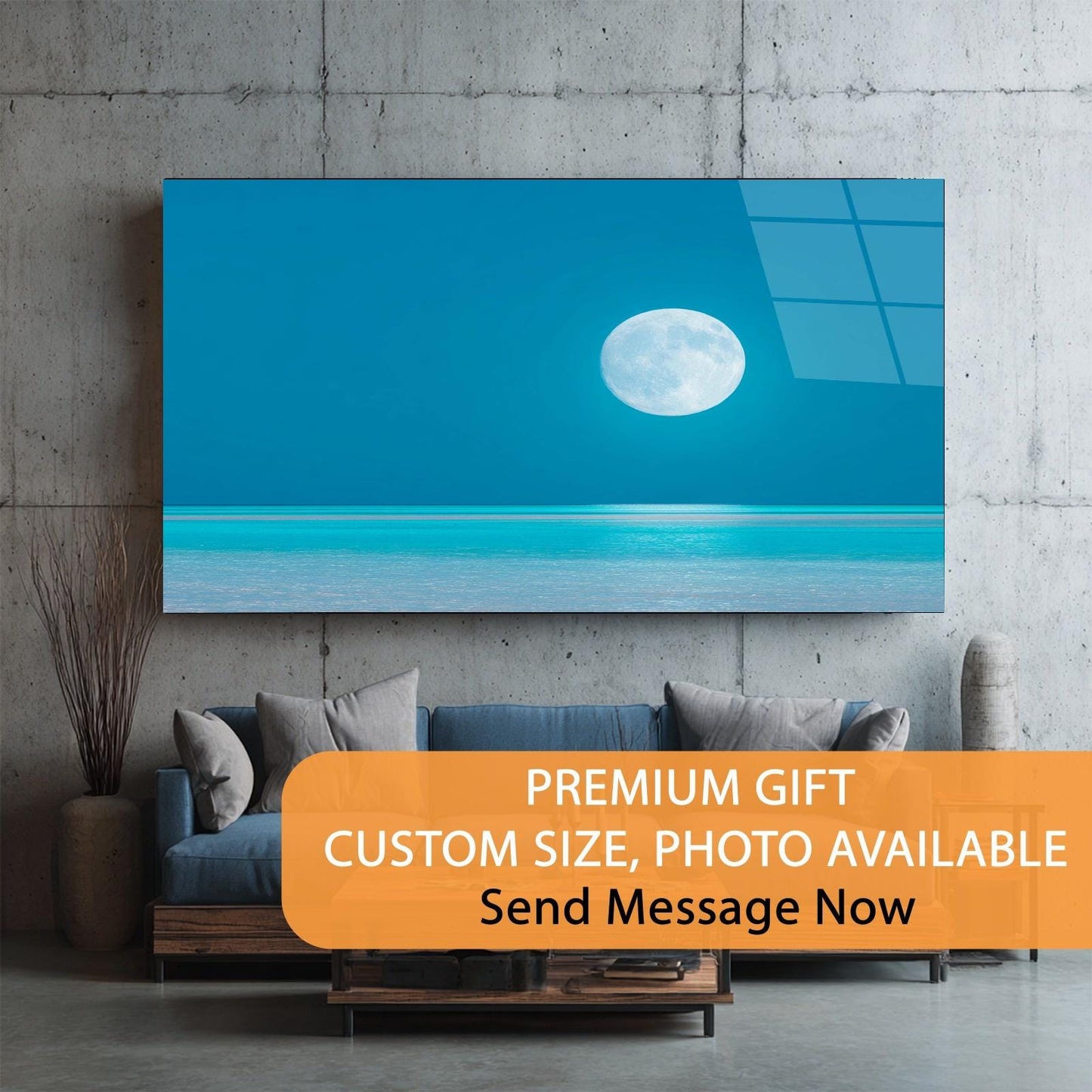 Canvas print of a moon over water hanging on a wall above a sofa.