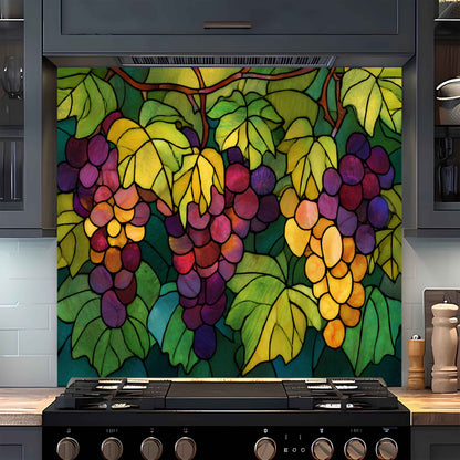 Colorful stained glass-style backsplash of grapes on a kitchen wall above a stove.