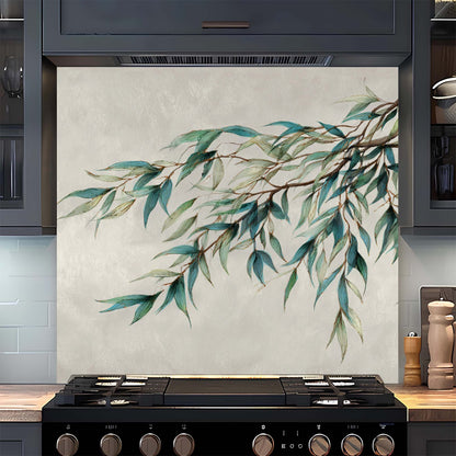 Decorative kitchen backsplash with green leaf design above a stove.