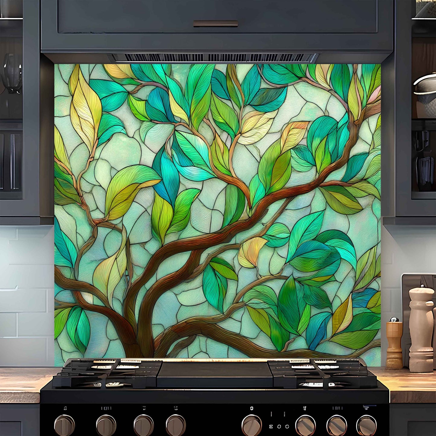 Decorative glass panel with tree design above a stove in a kitchen.