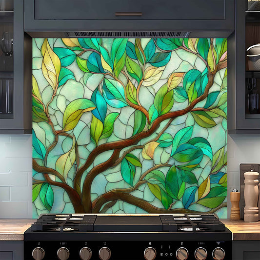 Decorative glass panel with tree design above a stove in a kitchen.