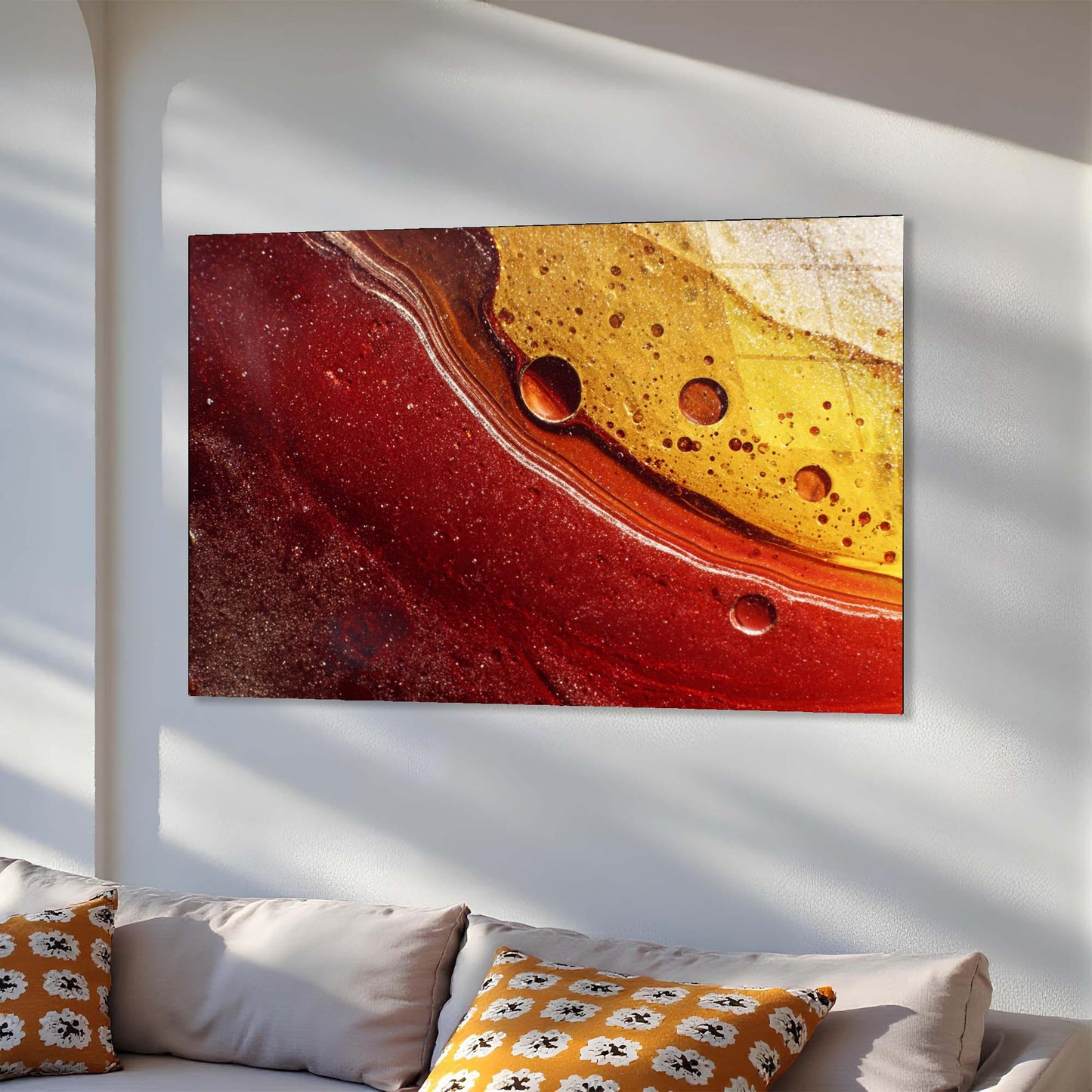 Abstract art piece with red and yellow colors on a white wall above a sofa.