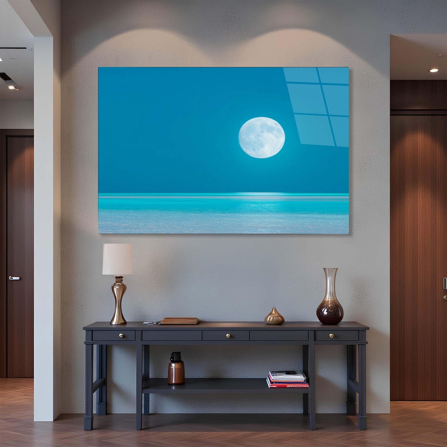 Modern interior with a large wall art piece of a moon over water, a console table with decorative items, and a lamp.