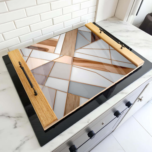 Stovetop with geometric glass cooktop and wooden sides on a kitchen counter.