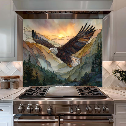 Stainless steel stove with a decorative backsplash featuring an eagle and mountain scene.