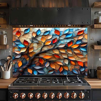 Stainless steel stove with colorful leaf-patterned glass backsplash in a kitchen setting