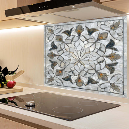 Decorative glass splashback with floral pattern above a kitchen stove