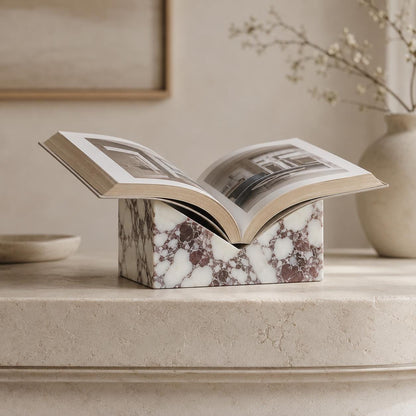 Calacatta marble book stand displaying an open book on a neutral shelf.