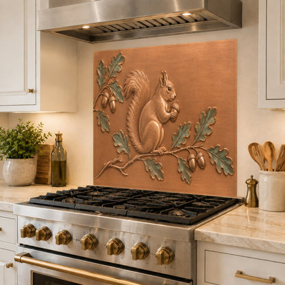 Sleek, grout-free glass kitchen backsplash with a detailed squirrel design installed behind a chef's range.