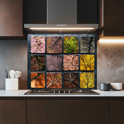 Modern kitchen with a decorative backsplash above the stove featuring seasonal tree patterns.