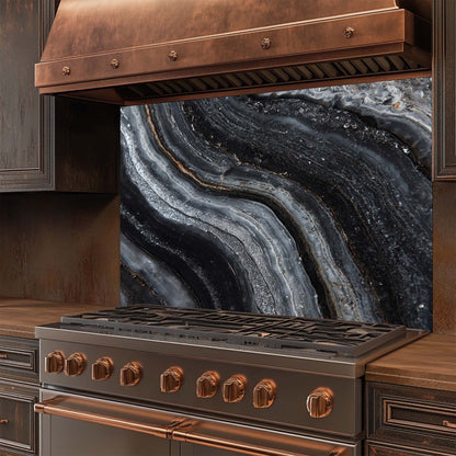 Stainless steel stove with copper accents and aglass splashback