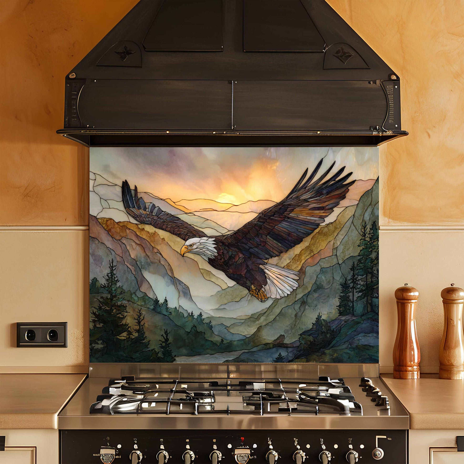 Stainless steel stove with a decorative backsplash featuring an eagle and mountain scene.