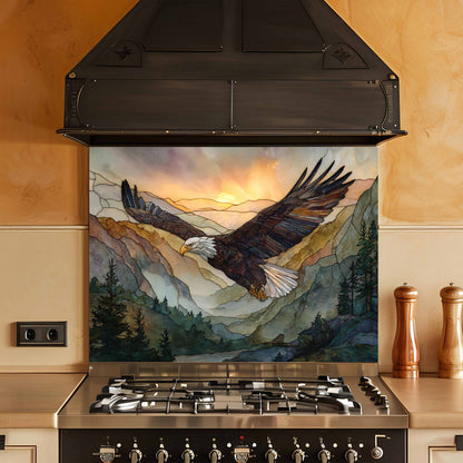 Stainless steel stove with a decorative backsplash featuring an eagle and mountain scene.