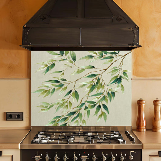 Kitchen stove with a decorative glass splashback featuring green leaves.